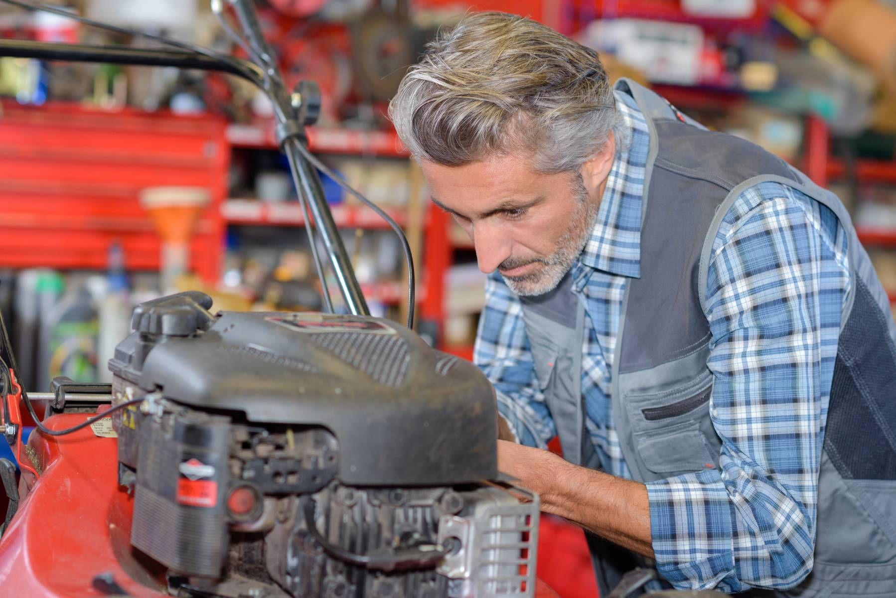 Mechanic working on mower deck in Louisiana workshop