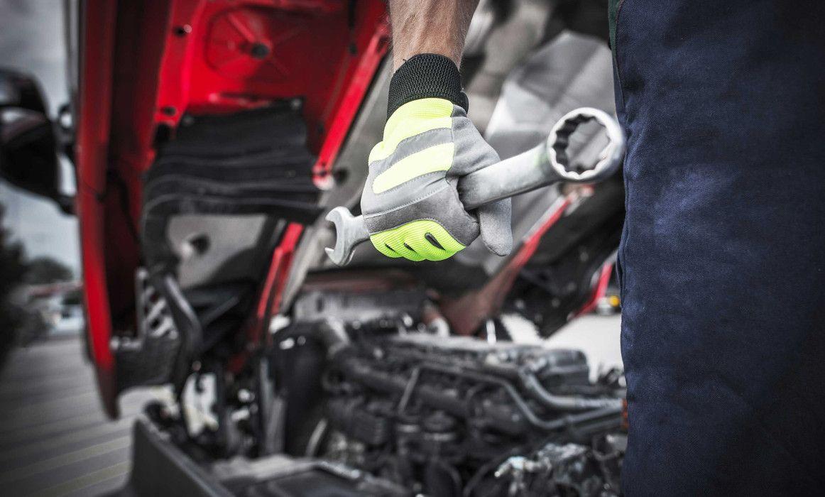 Technician inspecting tractor engine in Louisiana service bay
